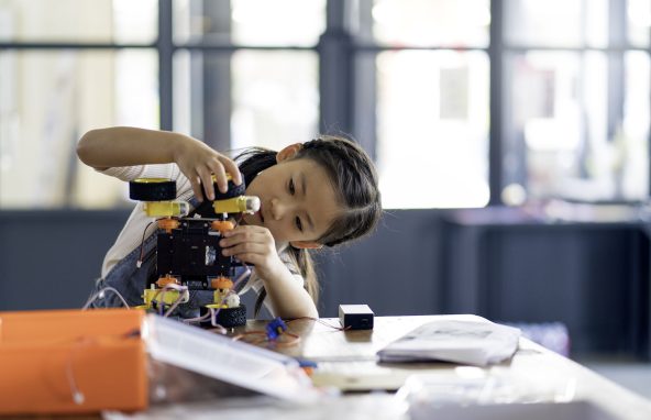 Young girl working on a robot design